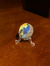 Load image into Gallery viewer, Image shows a labradorite palmstone with shimmering colours of blue and gold sat in a plastic stand.