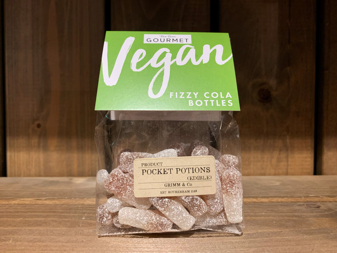 Image of a cellophane bag of edible Pocket Potion cola bottles with a green cardboard label on the top and a kraft brown name sticker on the front.