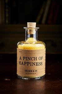 Image of A Pinch of Happiness otherwise known as scented yellow bath salts in a glass bottle with cork 