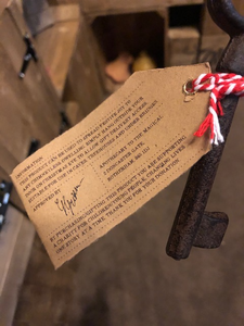 Image of Festive Entry Key - a metal decorative key tied with bakers twine and a kraft paper label showing the reverse information