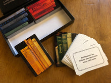 Load image into Gallery viewer, Image of the Twists and Tales cards partially out of the box, and displayed to see both sides of the cards. An example of one of the Setting cards can be read: 'An Intergalactic bar. Different alien species come here to watch sports.'