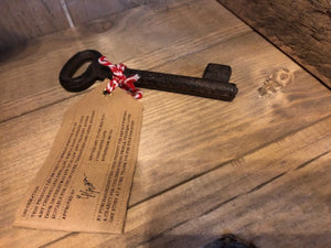 Image of Festive Entry Key - a metal decorative key tied with bakers twine and a kraft paper label showing the reverse information