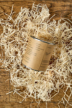 Load image into Gallery viewer, Image of the back of a tin of Disappointment with a kraft label showing the faux ingredients and side effects. Tin is sat in a nest of wood wool.