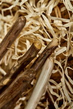 Load image into Gallery viewer, Close up image of a few handles of the handmade starter wands. Wooden decorative wands with polished bark handles and stripped bare polished wooden shafts. Woods are natural shades with grain pattern. Each wand comes with a wax sealed certificate of authenticity