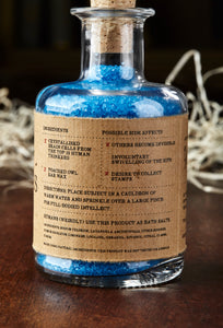 Image of the back label of Extract of Genius otherwise known as scented, blue bath salts in a glass bottle with cork. Back of label shows faux ingredients and side effects