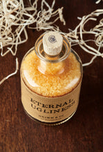 Load image into Gallery viewer, Top view image of Eternal Ugliness otherwise known as scented, orange coloured bath salts in a glass bottle with cork