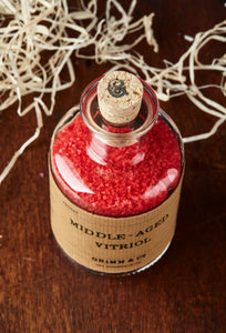 Top view of Middle Aged Vitriol potion bottle, a glass bottle and cork of red bath salts.