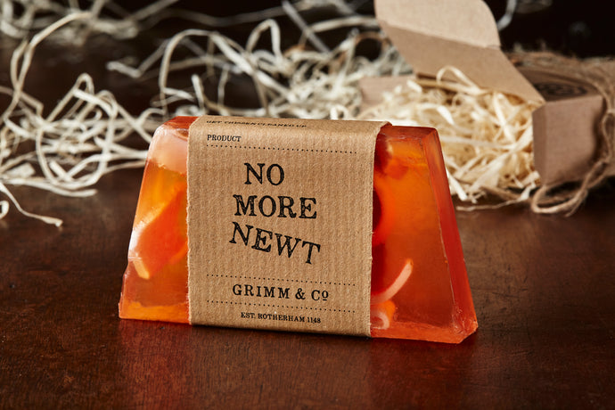 Image of No More Newt, an orange potion also known as an orange scented soap slice with a kraft paper label.
