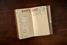 Load image into Gallery viewer, Image of an opened journal with an example of what it can be used for. It has a 'happy list' written on the dotted insert.