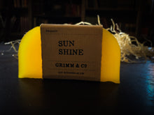 Load image into Gallery viewer, Image of a Sun Shine bar, a bright yellow solid shampoo slice with a kraft paper label