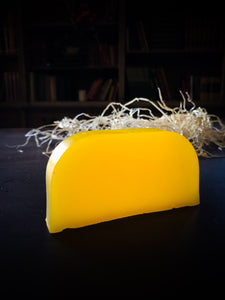 Image of a Sun Shine bar, a bright yellow solid shampoo slice shown without label