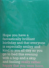 Load image into Gallery viewer, Image of front of greeting card featuring message in white text on teal background saying 'Hope you have a fantastically brilliant birthday and that everyone is especially smiley and kind to you all day so you go to bed this evening with a hop and a skip and feeling really rather happy that you were born'. The 'really rather happy that you were born' is printed in pink.