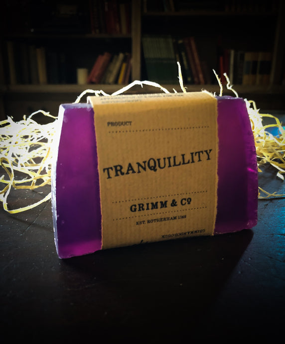 Image of a Tranquility bar, a purple solid shampoo slice with a kraft paper label