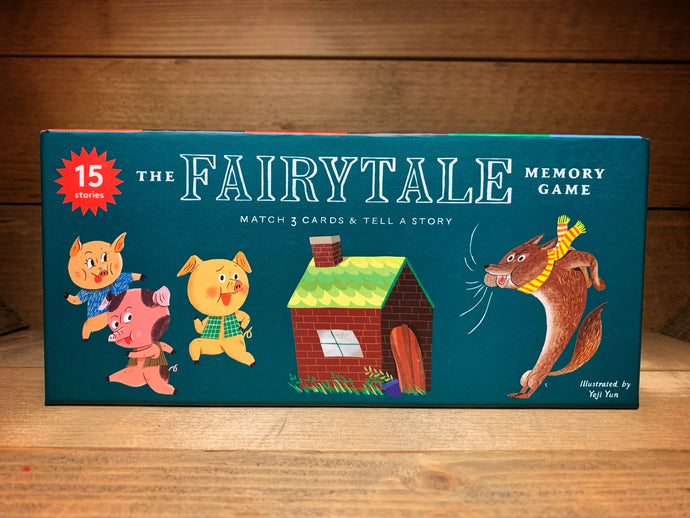 Image shows the front of the box of the Fairytale Memory Game with teal background and coloured illustrations of the three little pigs, a house made of bricks and the big, bad wolf.