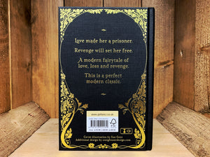 Image shows the back cover of the book A Pocketful of Crows. The blurb is embossed in gold, same as the front, surrounded by a continuation of the leaf patterns from the front.