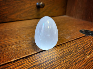 Image shows a close up view of  the egg shaped Blue Moon Crystal (selenite crystal).