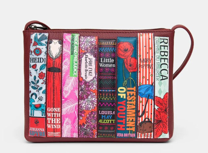 Image shows a cherry red leather zip-top, cross body bag featuring adjustable strap and 8 appliqued classic book spines written by female authors such as Heidi, Pride & Prejudice, Little Women and Mary Poppins.