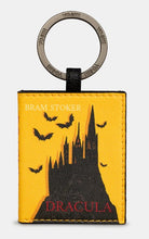 Load image into Gallery viewer, Image shows a PU leather keyring with stamped metal ring branded with YOSHI. Design resembles the book of Dracula with a front cover featuring a silhouetted castle and flying bats. The title is printed in red text and the author in white.