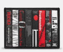 Load image into Gallery viewer, Image shows a black leather card holder with appliqued design featuring book spines of classic horror titles in grey, black and red.