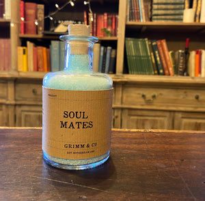 Image of a glass potion bottle filled with pale blue bath salts. The bottle label reads: Soul Mates.
