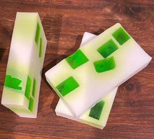 Load image into Gallery viewer, Image shows three Goblin Mucus soap slices stacked in a little pile. The soap is white with vivid green squares dotted throughout as the soap set.