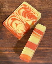 Load image into Gallery viewer, Image shows a slice of the Human Blood, Sweat &amp; Tears soap with a red and cream swirl pattern.