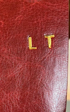 Load image into Gallery viewer, Image shows the initials LT embossed onto a burgundy journal using gold foil.