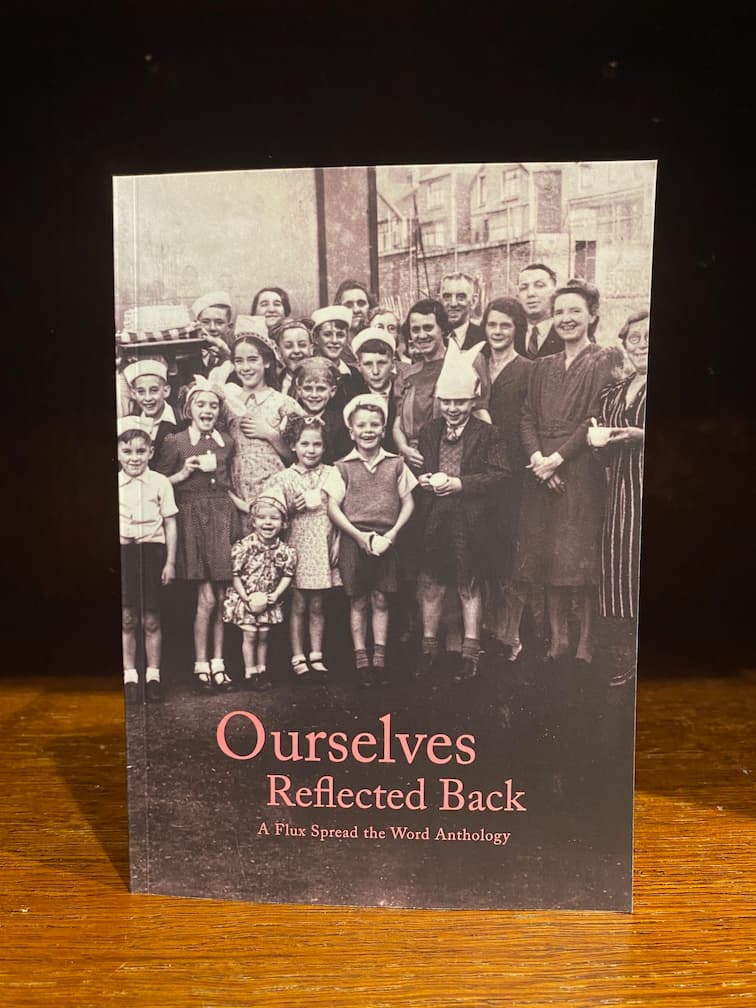 Image shows the paperback front cover of Ourselves Reflected Back poetry anthology by Flux Rotherham. Cover is a black and white photo of a Rotherham street party c. 1945.