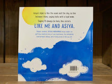 Load image into Gallery viewer, Image of the back cover of The Proudest Blue. The background is white, and running across the lower section under the blurb is more of the blue hijab illustration from the front, but this time flowing as a section of sly rather than waves, with white clouds and birds, and a yellow sun above. The blurb is written in blue and black text.