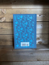 Load image into Gallery viewer, Image of the Penguin clothbound classic Wuthering Heights featuring a blue-grey background with a blue repeat printed pattern of rose buds and thorny stems winding up the cover. 