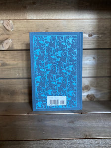 Image of the Penguin clothbound classic Wuthering Heights featuring a blue-grey background with a blue repeat printed pattern of rose buds and thorny stems winding up the cover. 