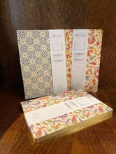 Load image into Gallery viewer, Image shows a selection of three patterned A5 notebooks with different designs, featuring colours including red, green, purple, orange and blue on an ivory background with gold powder finish. Designs vary including geometric tile patterns and floral patterns.