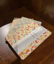 Load image into Gallery viewer, Image shows a selection of three patterned A5 notebooks with different designs, featuring colours including red, green, purple, orange and blue on an ivory background with gold powder finish. Designs vary including geometric tile patterns and floral patterns.