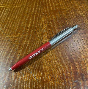 A red and chrome coloured retractable biro pen with the words 'Grimm & Co.' in white text against the red shaft.