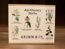 Load image into Gallery viewer, Image shows the box for the Apothecary Herbs seed collection. The box is a small, flat, rectangular 5 x 4 inch box made of kraft card, and has a white label folded over and underneath. The label has &#39;Apothecary Herbs&#39; printed at the top, and 6 illustrations of the flowers/herbs contained within, with both common and scientific names listed underneath. The Grimm &amp; Co. logo is printed at the bottom. 