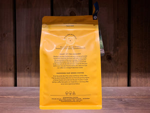  Image of the back of the coffee packet. it is bright yellow, with black text.