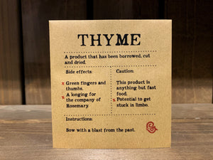 Image shows a packet of Thyme seeds. It is a square, flat, kraft brown paper packet., with black text printed in Appareo font. It says Thyme at the top, with magical ingredients and side effects printed underneath, and a magical 'caution' at the bottom.