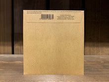 Load image into Gallery viewer, Image shows the back of a seed packet. It is made of kraft brown paper, and is sealed shut with a folded flap. At the top of the flap there are instructions written in small font. 