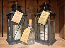Load image into Gallery viewer, Image shows the full Bright Ideas collection featuring the Bottle and Lantern styles. Image shows a black and bronze coloured plastic lantern with the glass bottle Bright Ideas in the front. Lanterns contain a battery operated candle, bottle contains LED battery operated string lights inside.