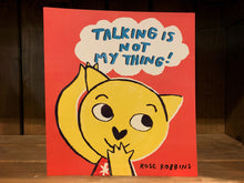 Load image into Gallery viewer, Image shows the front cover of Talking is Not My Thing. It has a bright red background, with the illustration of a yellow cat wearing a red shirt/dress. One hand is covering her mouth, the other is reaching up towards a thought bubble, where the title is written in blue text.