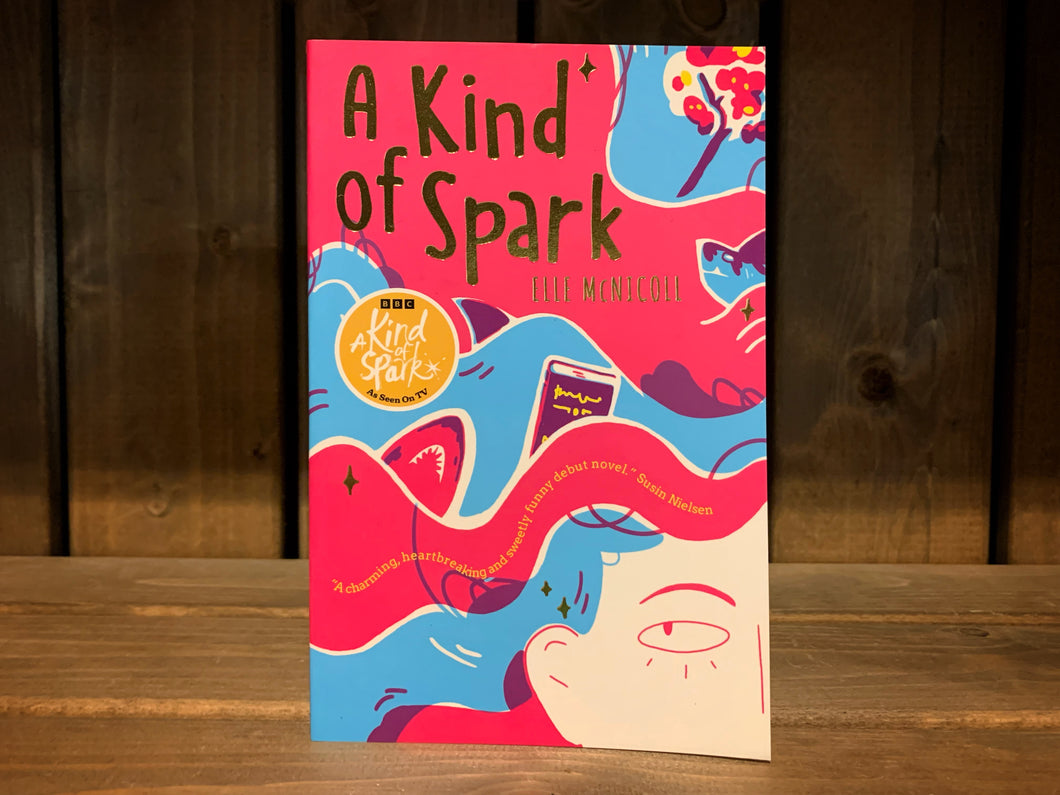 Image of the cover for A Kind of Spark. The cover has an illustration of the top quarter of a girls face in the bottom right corner, the rest of the cover is her flowing hair in stripes of red and blue, with sharks and books. 