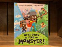 Load image into Gallery viewer, Image of the front cover of We&#39;re Going to Find the Monster. The cover has an illustration of two black boys standing on a green hill. One if wearing a cape and a saucepan on his head, the other carries a rucksack and wears a pilots cap. Behind them are three different environments - the sea and a whale, mountains and a wolf, and jungle with a tiger.