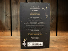 Load image into Gallery viewer, Image of the back cover of The Book Thief. The cover is black, with a few yellow dots/stars in the upper left and bottom right corner. On the opposite corners are the illustrations of death and the girl dancing. The blurb is written in the middle in yellow and white text.
