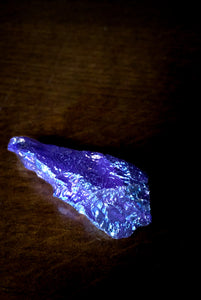 Image of a Unicorn Horn Polisher, otherwise known as quartz stones plated in different metals to provide a rainbow sheen. The Unicorn Horn Polisher in this image is blue in colour and pointed in shape.