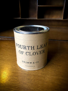 Image of Fourth Leaf of Clover green and gold shimmer ink sealed inside tin with lid closed and kraft paper label