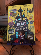 Load image into Gallery viewer, Image of the front cover of the paperback book The Nothing to See Here Hotel, written by Steven Butler and illustrated by Steven Lenton. Displayed on a book stand.