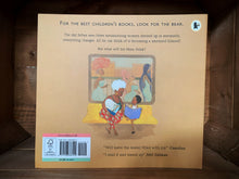 Load image into Gallery viewer, Image of the back of the book Julian is a Mermaid. The cover has a pale orange background, and an illustration of the boy from the front cover sat with his grandmother on a bench, while three women with fancy dresses and hairstyles are walking past a window behind them.