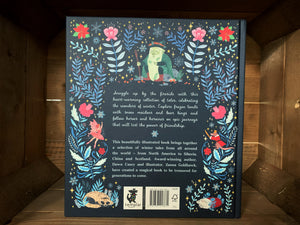 Image of the back of the book Winter Tales. The back cover is dark blue, with the blurb in the center written in pale blue text. The  illustrations of flowers and stars continue from the front, and there are also illustrations of an old man with a staff, fairies, witches, and a fox and a mouse. 