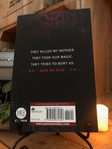 Image of back cover of the paperback book Children of Blood and Bone stood in book stand