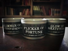 Load image into Gallery viewer, Image of full range of candles in tins showing Glimmer of Confidence, Flicker of Fortune and Glow of Gratitude